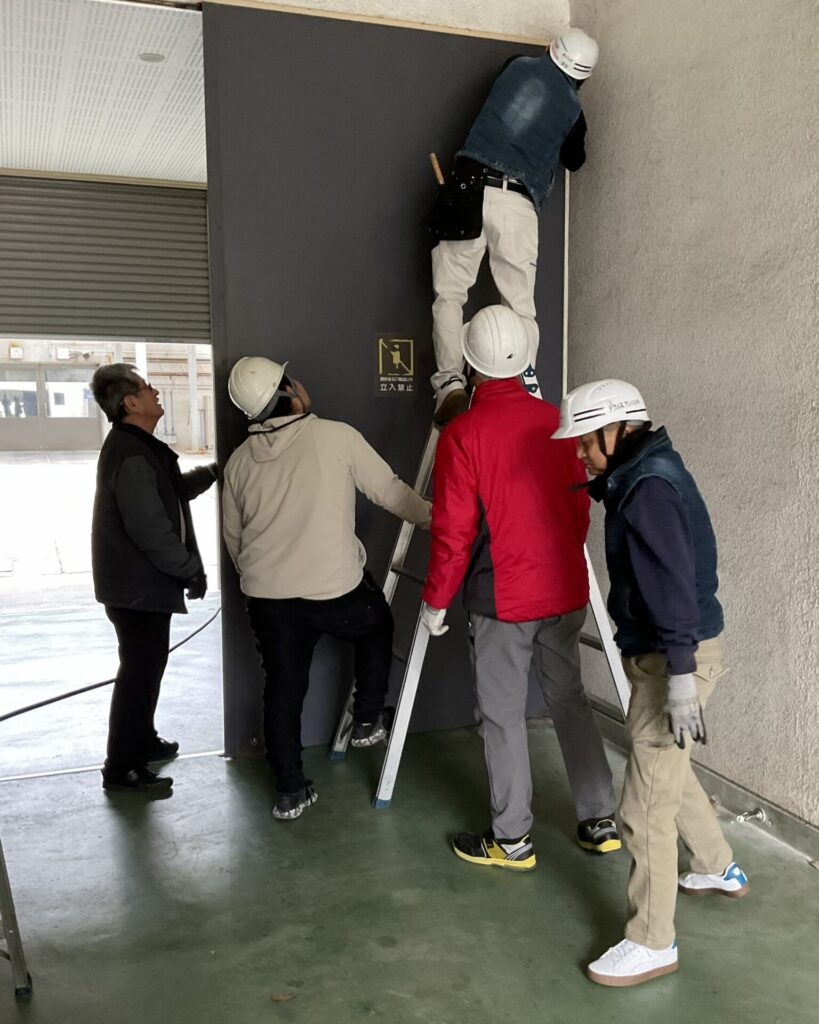 フロアヒンジ 交換の様子。ヒンジのケースを開口→ヒンジのビスを緩める→扉を取り外す。